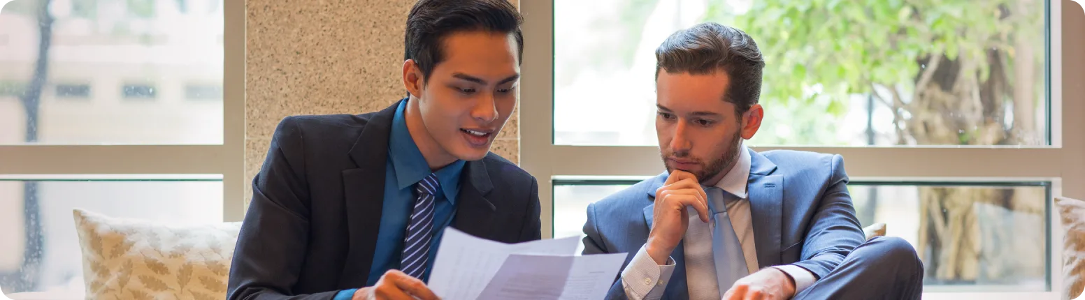 Two colleagues reviewing financial documents together.